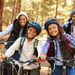 Portrait,Of,Family,Cycling,Through,Fall,Woodland