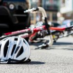 Close-up,Of,A,Bicycling,Helmet,Fallen,On,The,Asphalt,Next