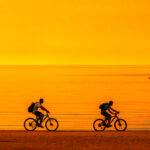 Biker,Silhouette,Riding,Along,Beach,At,Sunset,On,Bike,Sporty