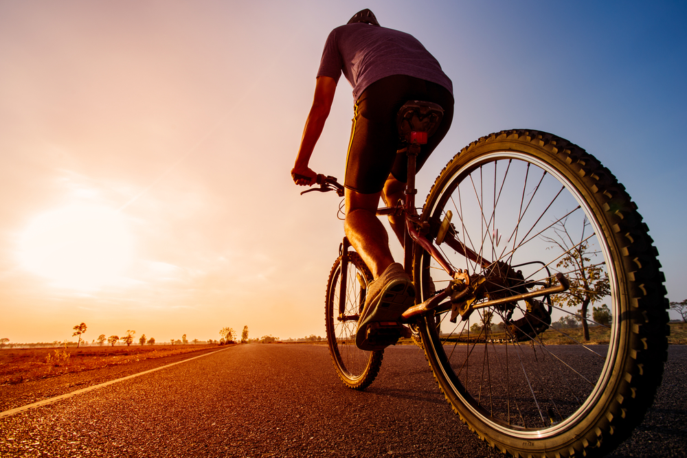 Asian,Men,Are,Cycling,Road,Bike,In,The,The,Sunset