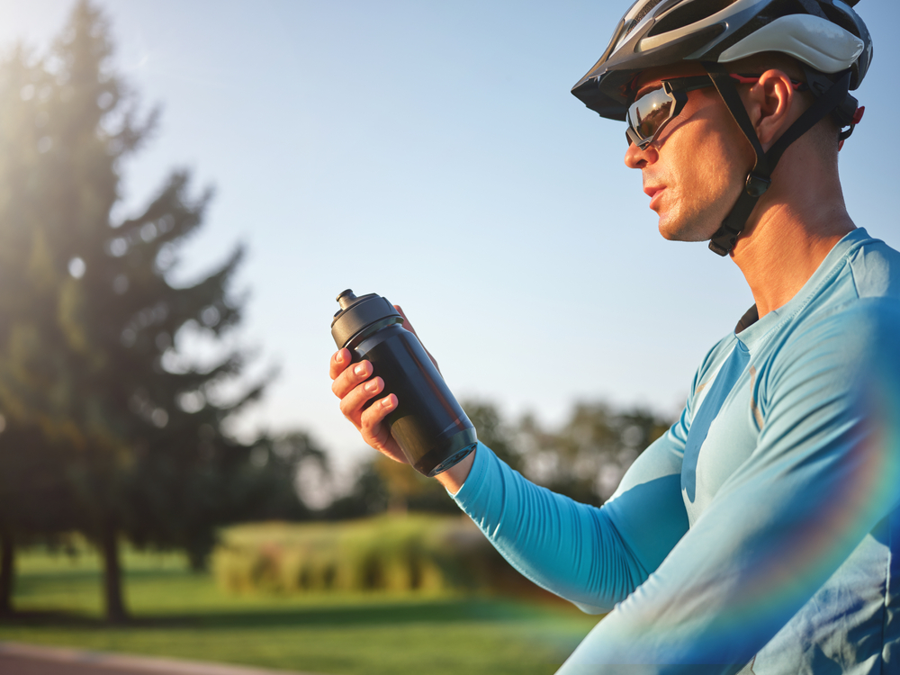 Hydration,Matters.,Professional,Male,Cyclist,Holding,Water,Bottle,,Standing,With